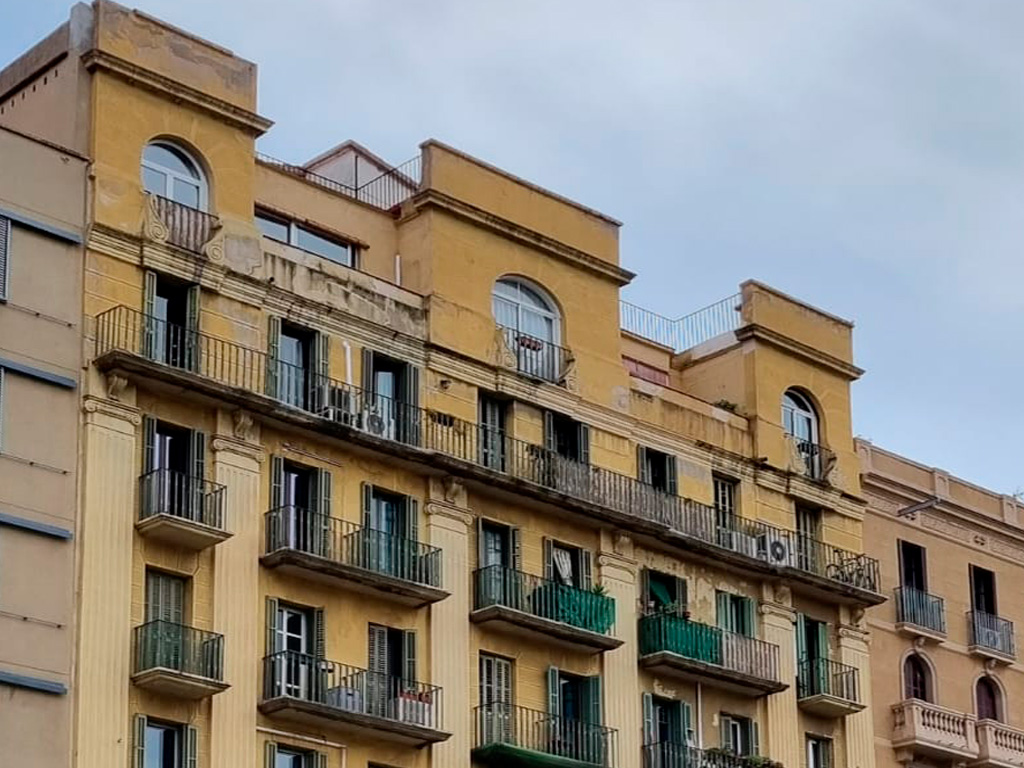 Vista de la parte superior de la fachada antes de la rehabilitación de la fachada del edificio en Gran Vía, 826 de Barcelona por GTA Europa